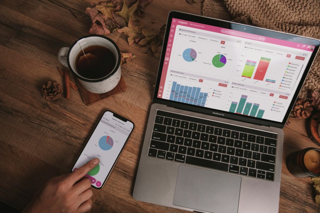 Budgettabelle auf dem Laptop und Ausgaben-App auf dem Smartphone