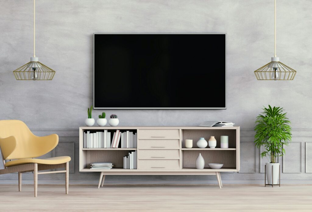 Gebündelte Leitungen hinter einem Fernseher an der Wohnzimmerwand