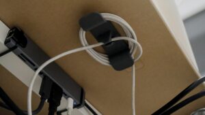 Kabelhalter mit aufgerolltem Kabel unter einem Schreibtisch