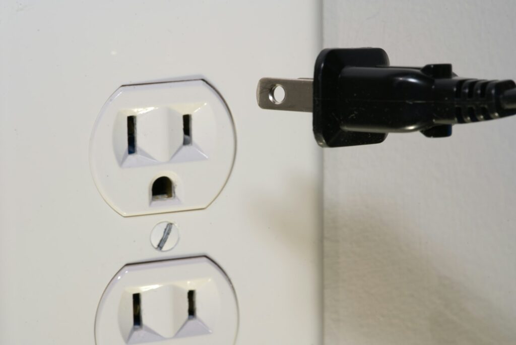 Stecker vor einer Steckdose
