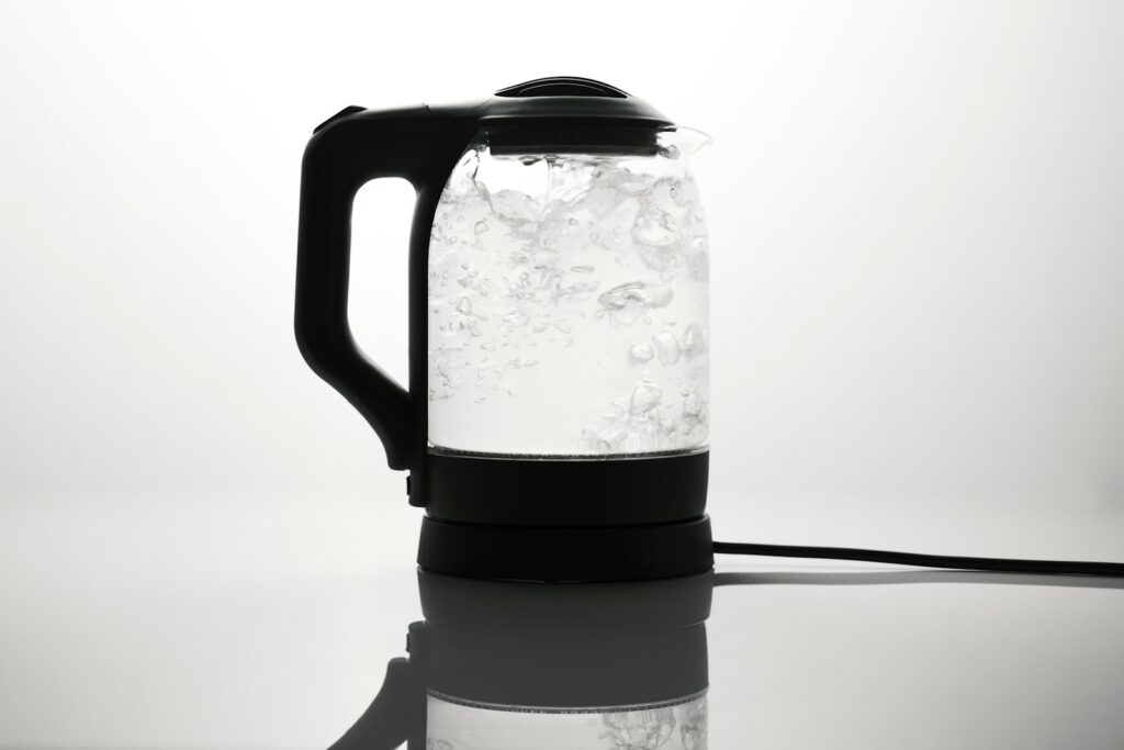 Weiße Kalkablagerungen am Boden eines Wasserkochers aus Edelstahl